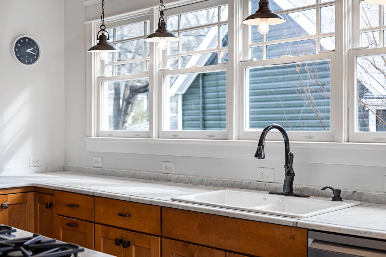 Bright kitchen featuring marble countertops, stylish lighting, and scenic windows.